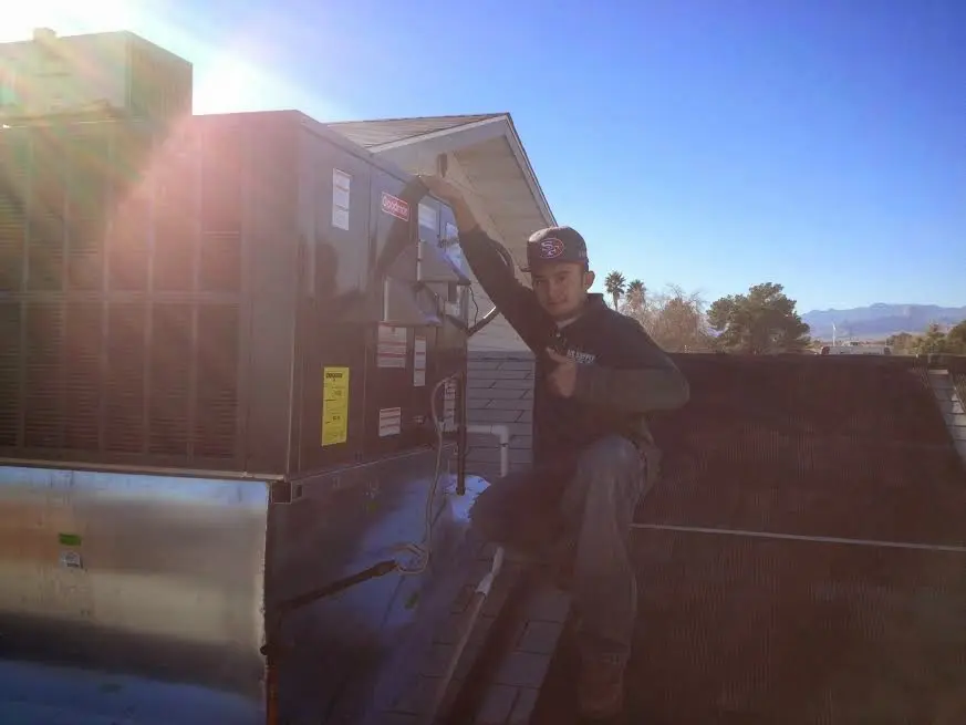 HVAC technician performing AC Tune-Up on a rooftop unit in Murrieta
